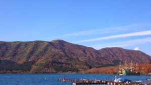 紅葉に染まる山並みと芦ノ湖の湖面