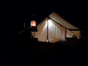 夜のキャンプ場で照らされたテントとランタン