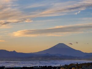 富士山と波が見える夕暮れの海、浜辺に近い視点