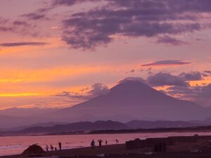 夕焼けに染まる空と富士山のシルエットが美しい湘南の海岸風景