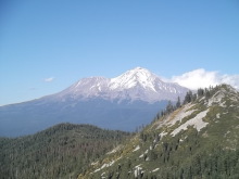 カリフォルニア州のシャスタ山の遠景写真。森林に囲まれた山頂