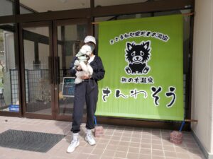 さんわ荘の入口で記念撮影する飼い主と愛犬