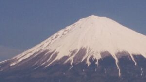 雪をかぶった富士山の山頂、春の空に映える日本の象徴的な風景